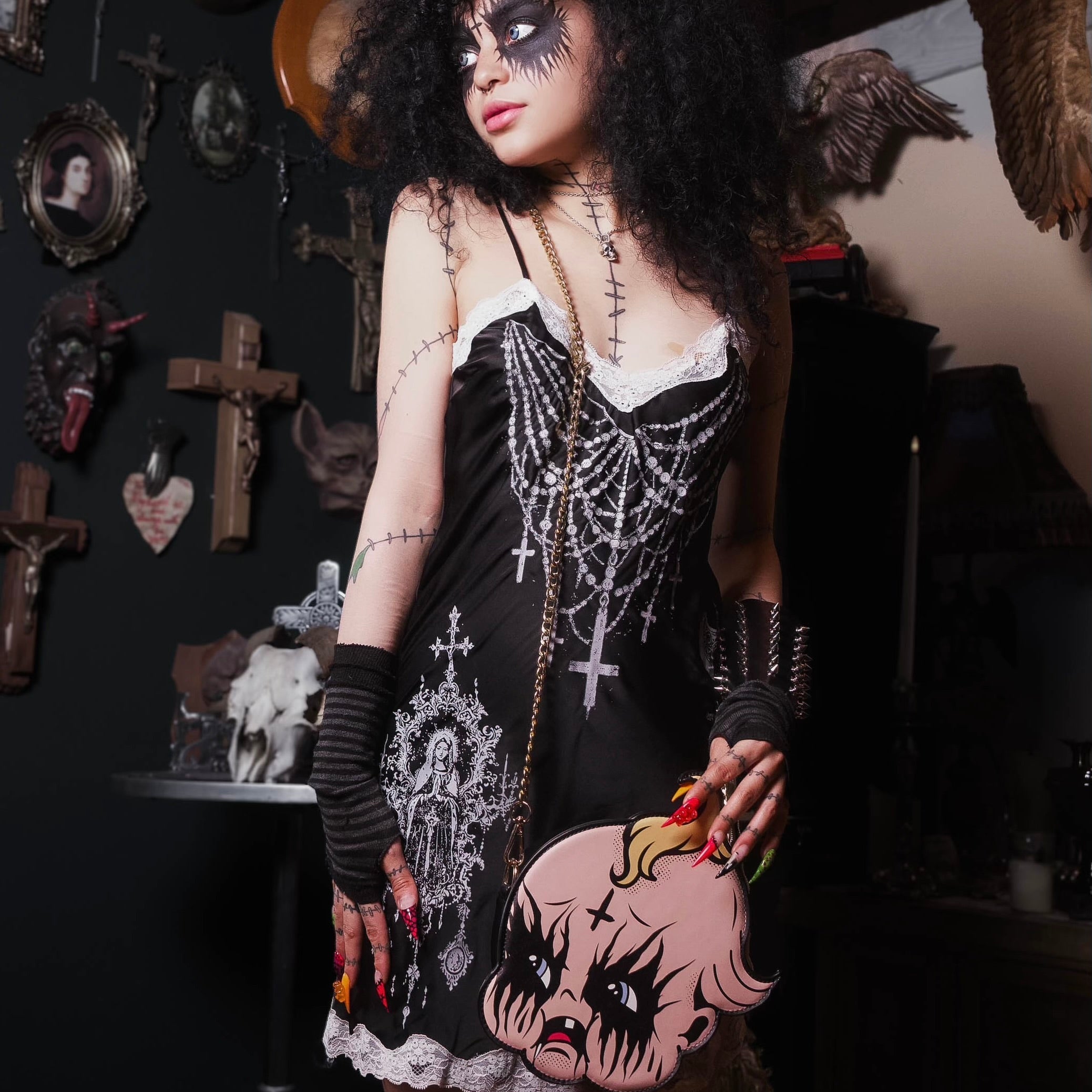 Person in a dark, gothic-style setting with decorative elements on the wall.