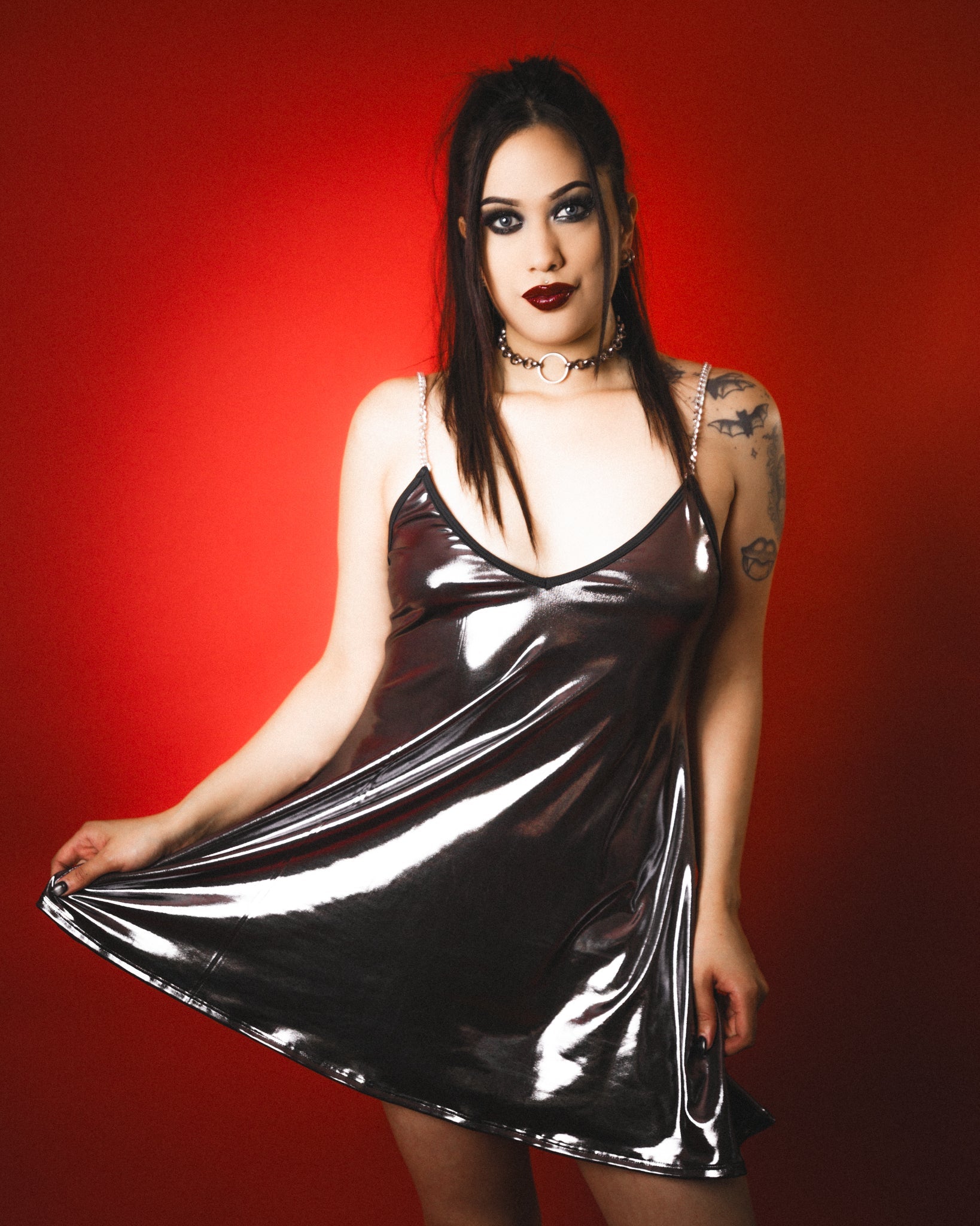 Woman wearing a metallic silver dress against a red background