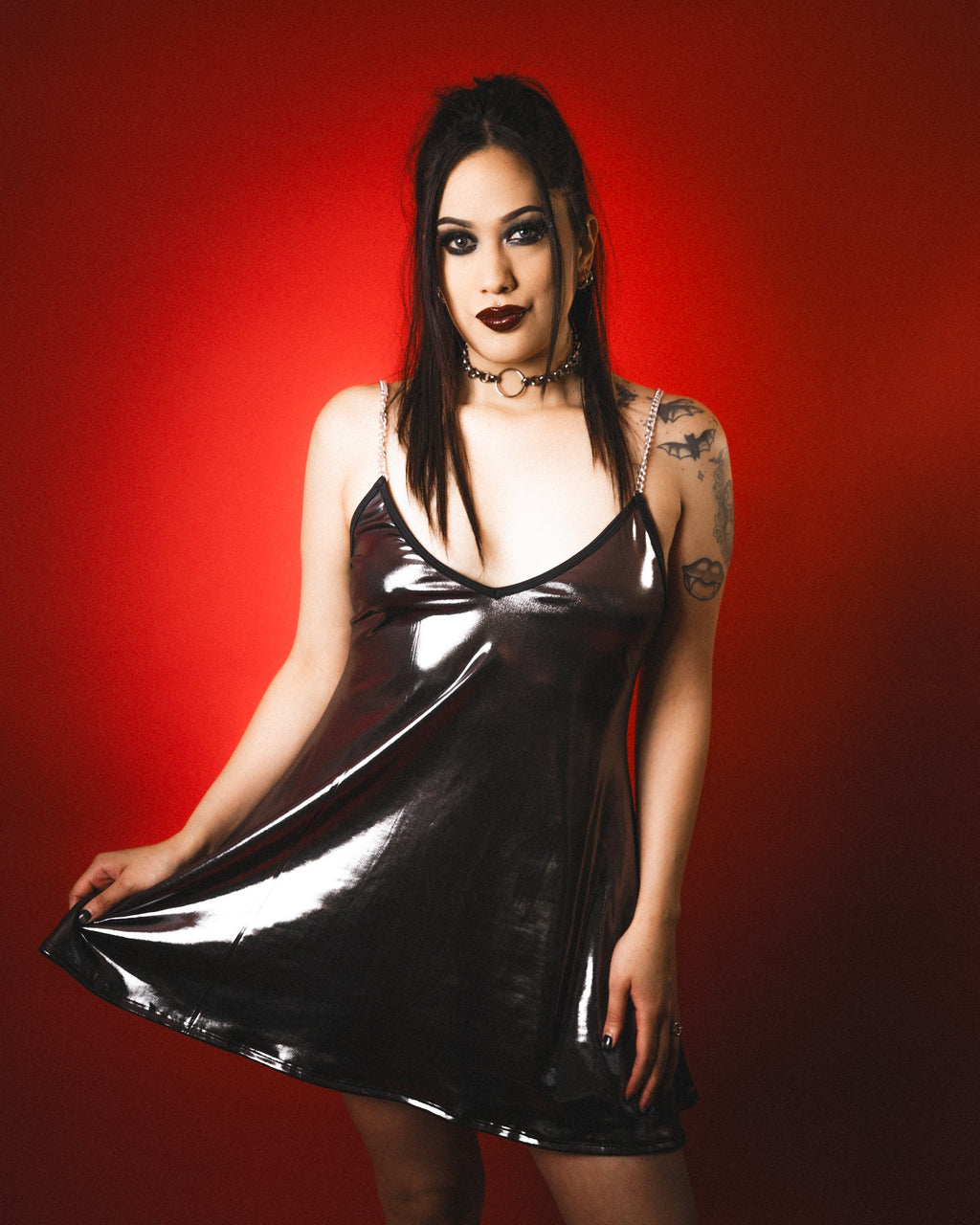 Woman wearing a black metallic dress against a red background