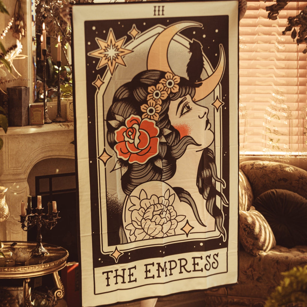 Poster of 'The Empress' tarot card in a cozy room with candles and decor.