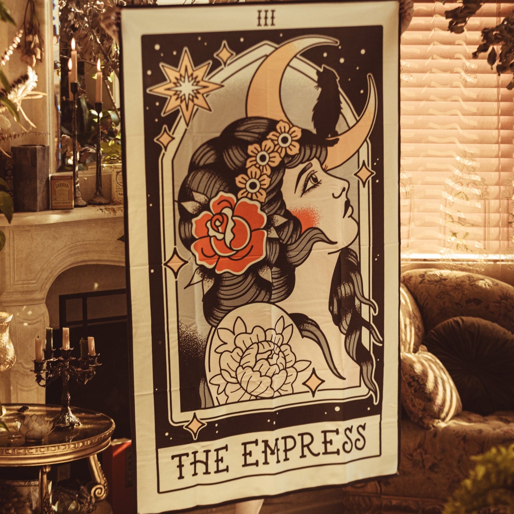 Poster of 'The Empress' tarot card in a cozy room with candles and decor.