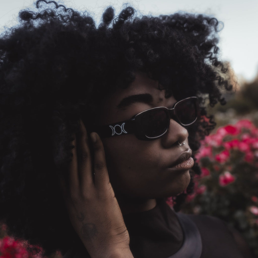 Person wearing sunglasses with a floral background