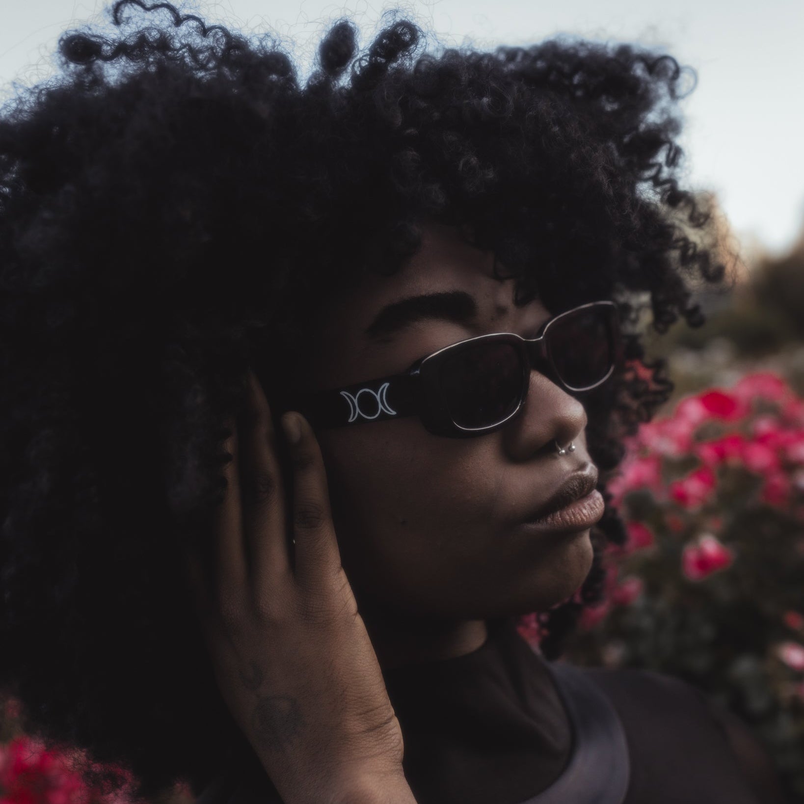 Person wearing sunglasses with a floral background