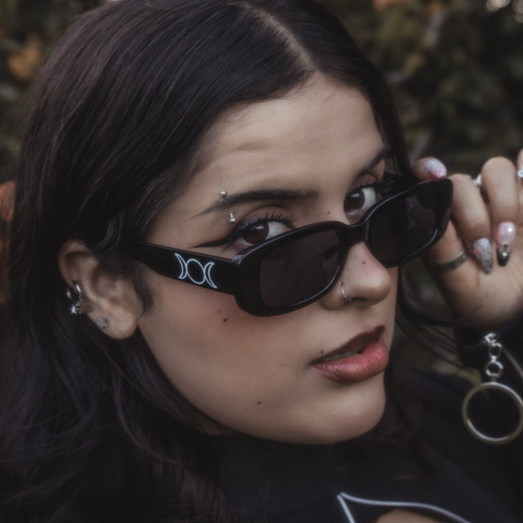 Person wearing black sunglasses with a blurred natural background