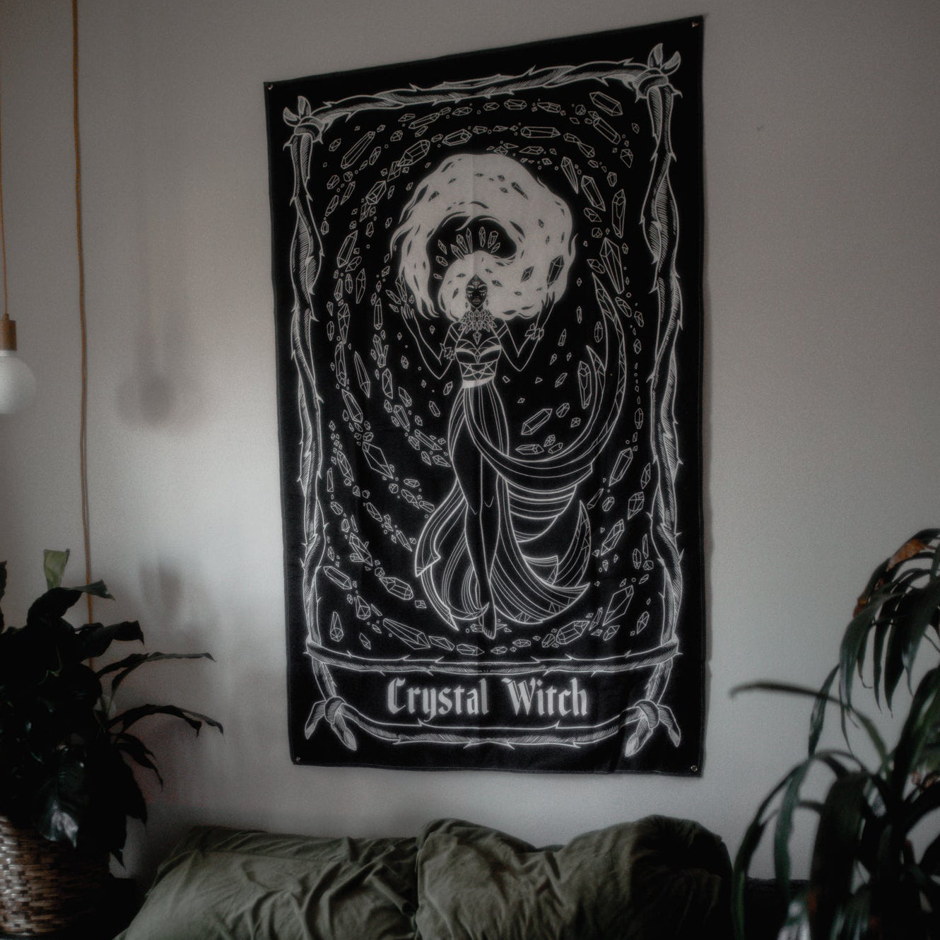 Room interior with a 'Crystal Witch' tapestry on the wall above a bed.