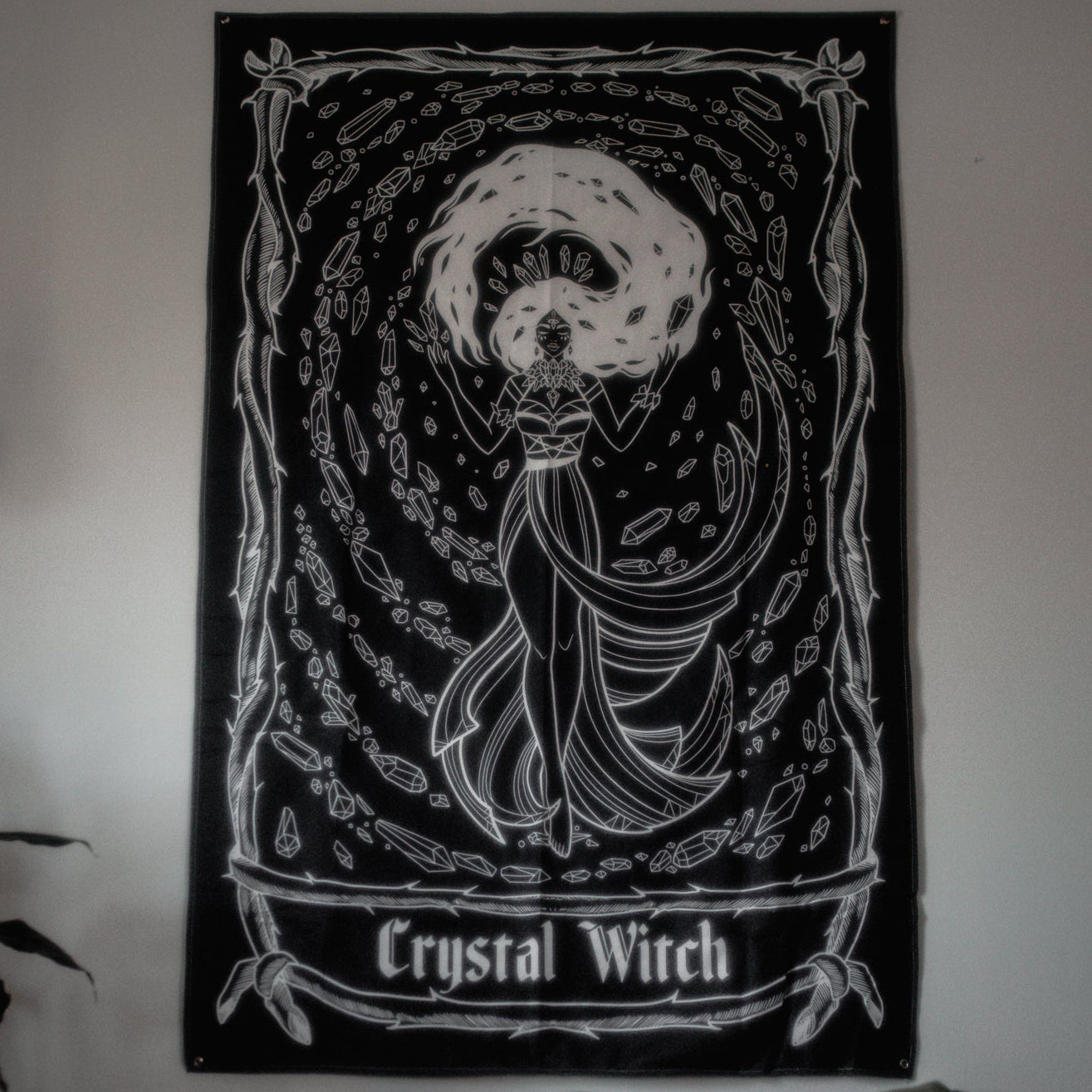 Poster of a 'Crystal Witch' design on a wall above a bed.