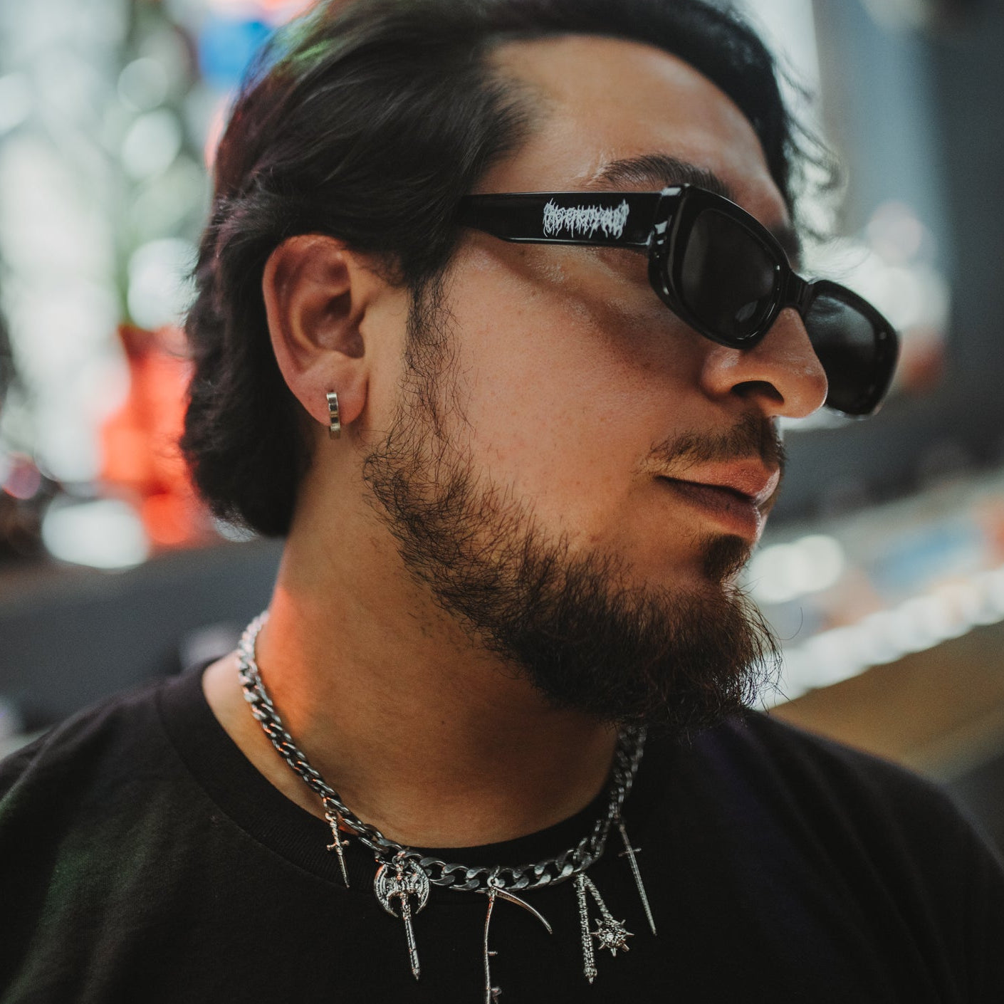 Man wearing sunglasses with a blurred colorful background