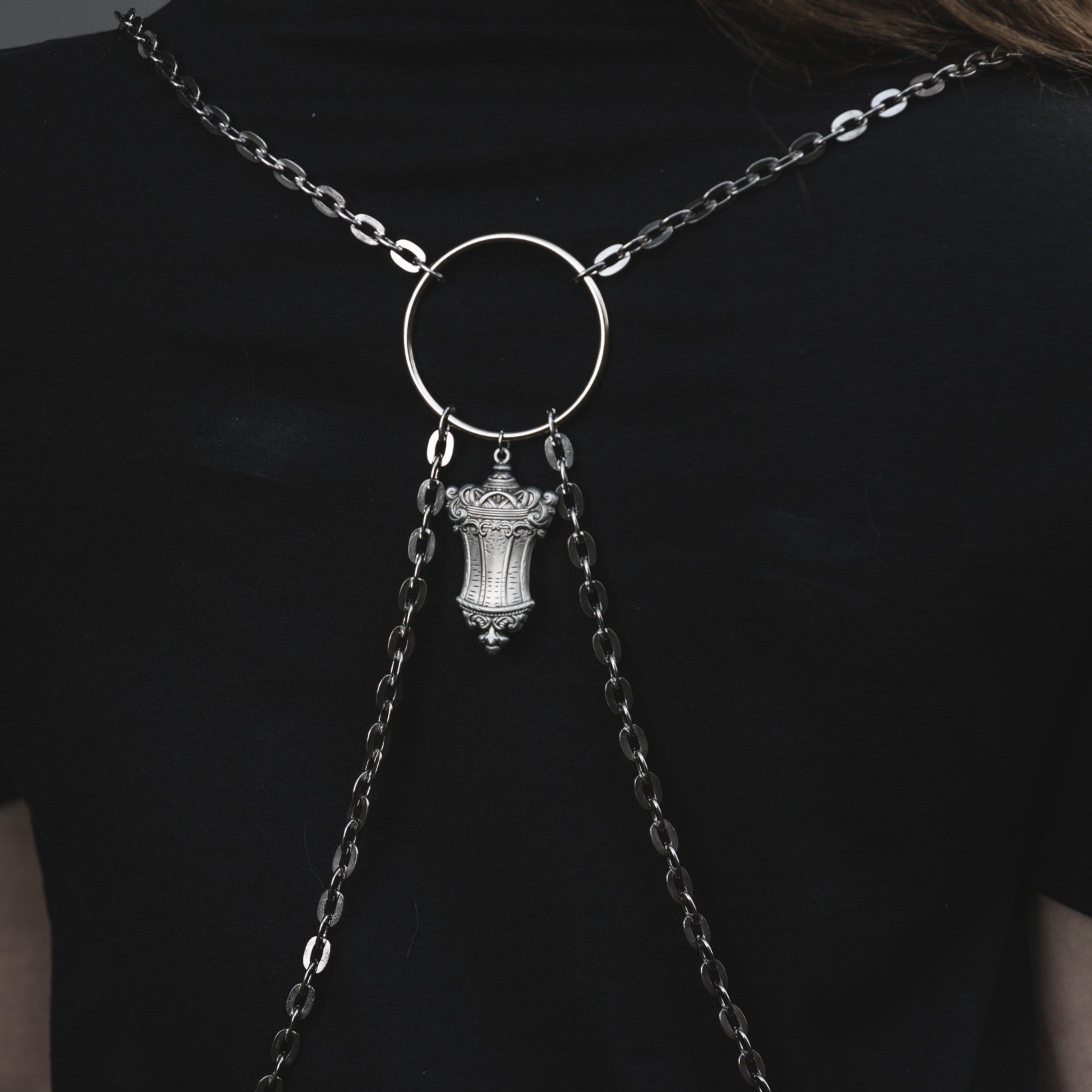 Silver chain necklace with a pendant on a black background
