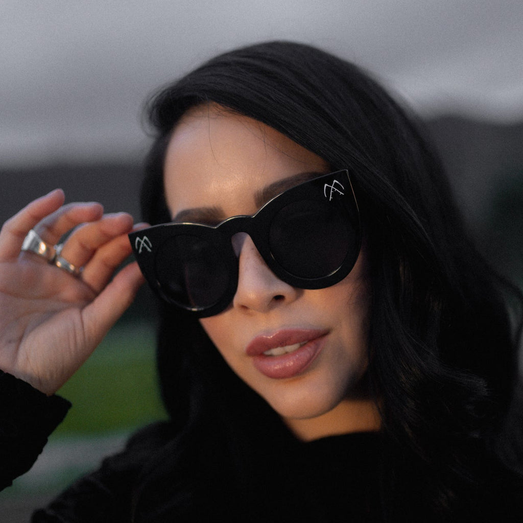 Woman wearing black sunglasses with a blurred background