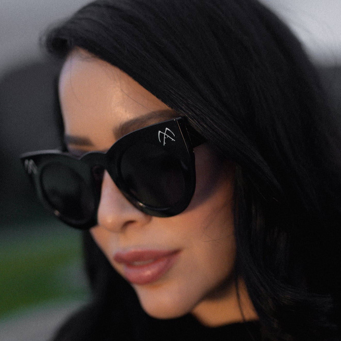 Person wearing black sunglasses with a blurred background
