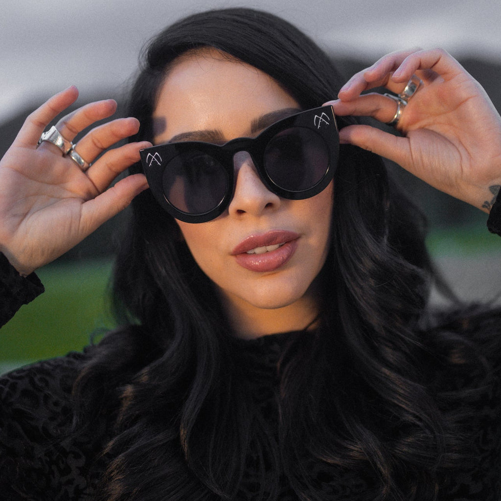 Woman wearing black sunglasses with a blurred background