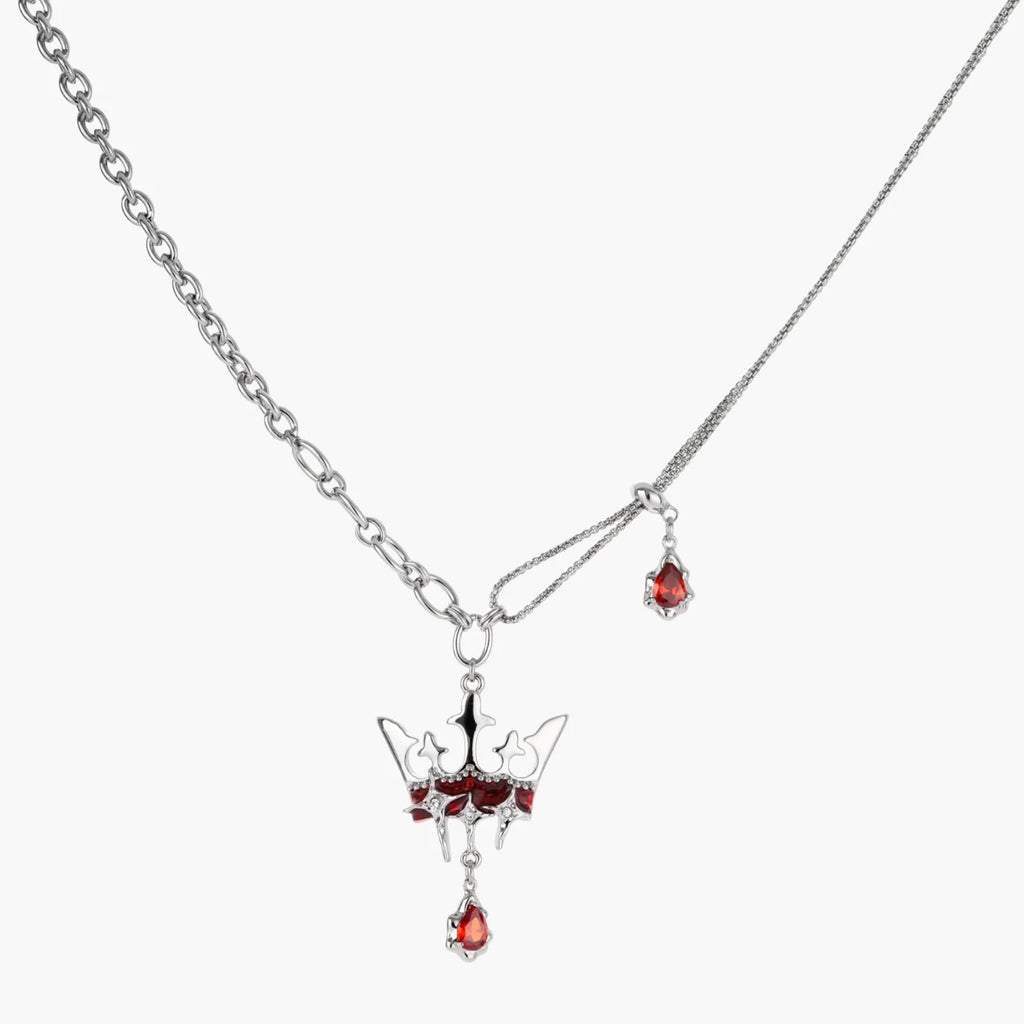 Silver necklace with red gemstone pendant on a white background
