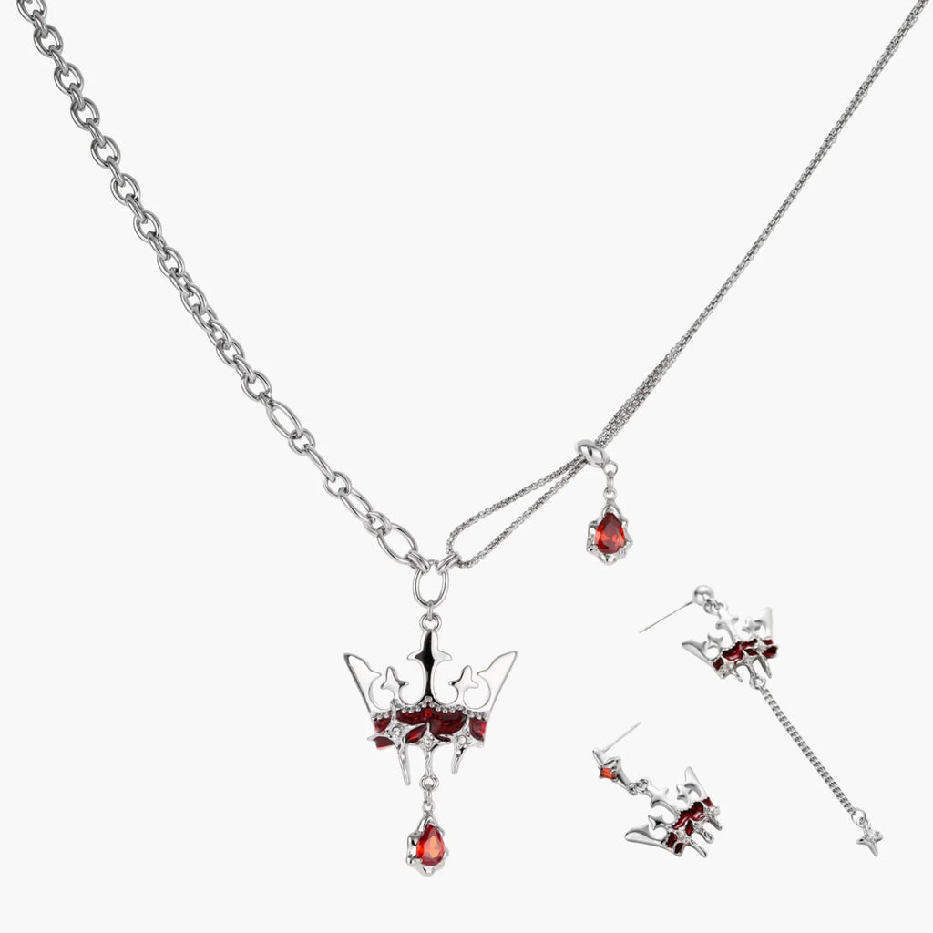 Silver jewelry set with red gemstones on a white background