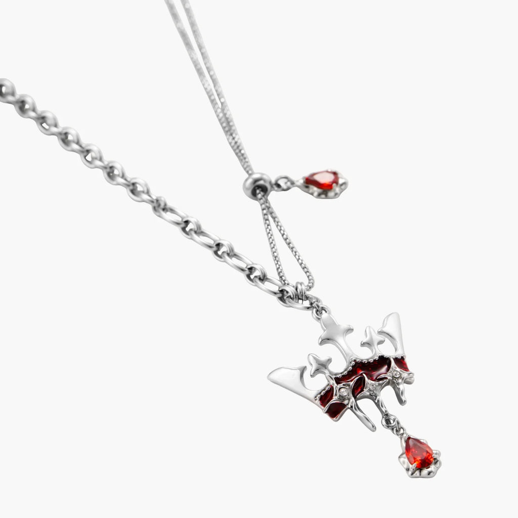 Silver necklace with red gemstone pendant on a white background