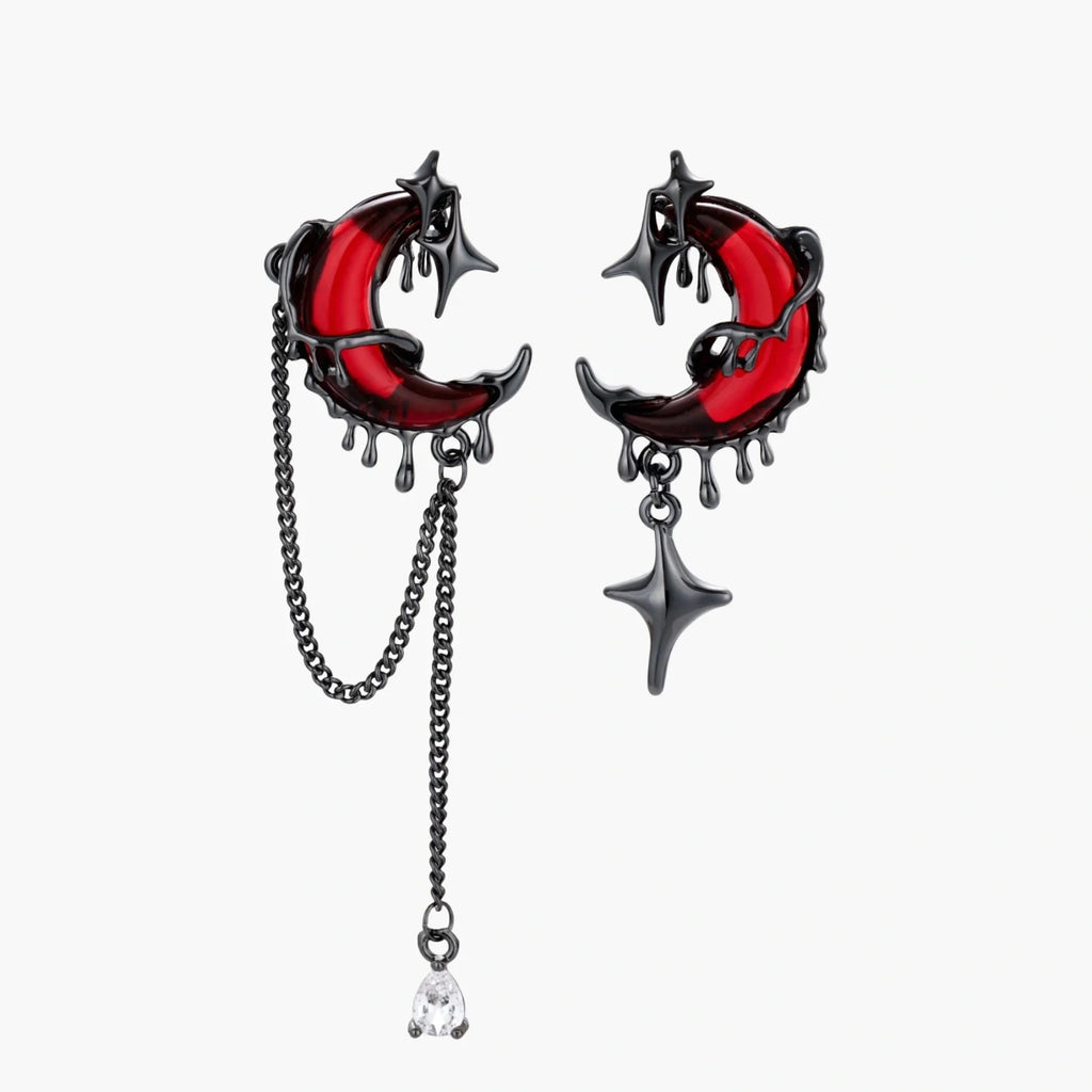 Pair of earrings with red crescent moon and star design on a white background