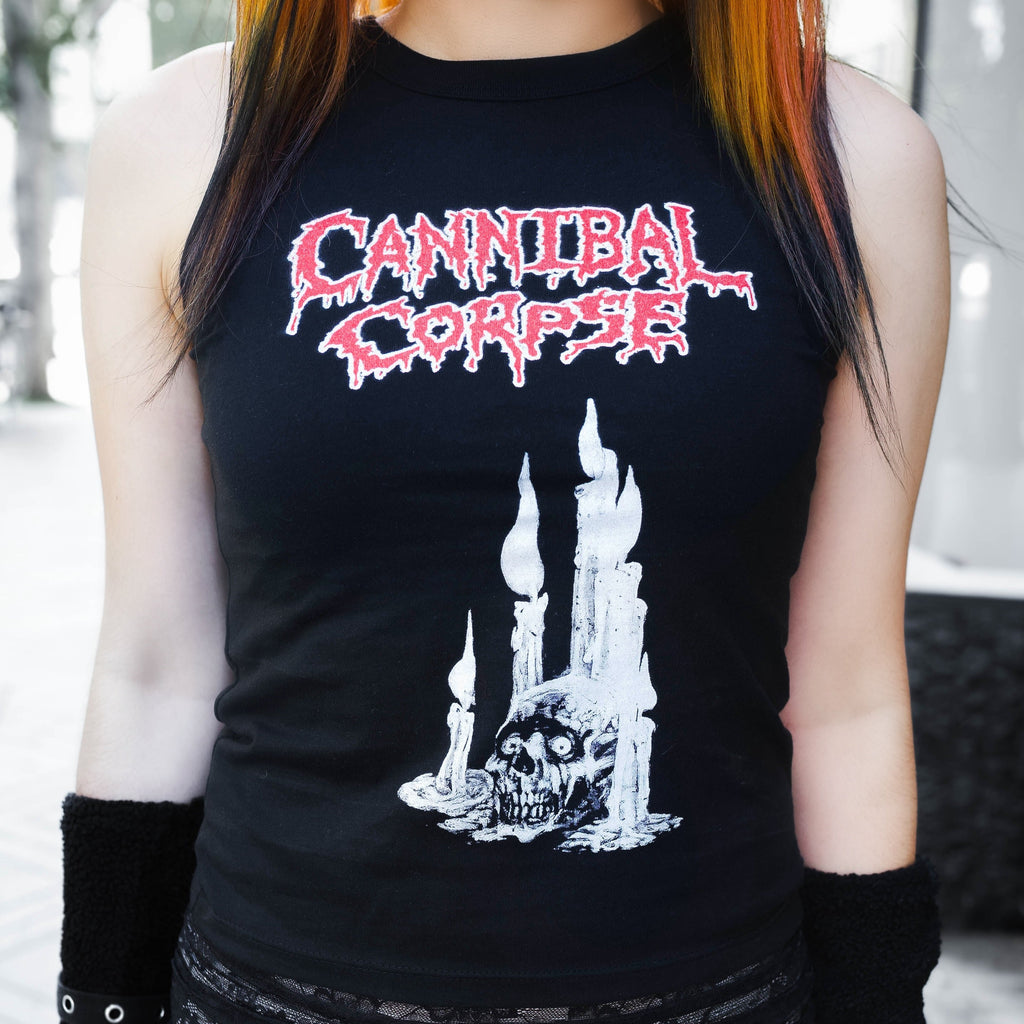 Person wearing a black sleeveless shirt with 'Cannibal Corpse' logo and design, paired with a black lace skirt.