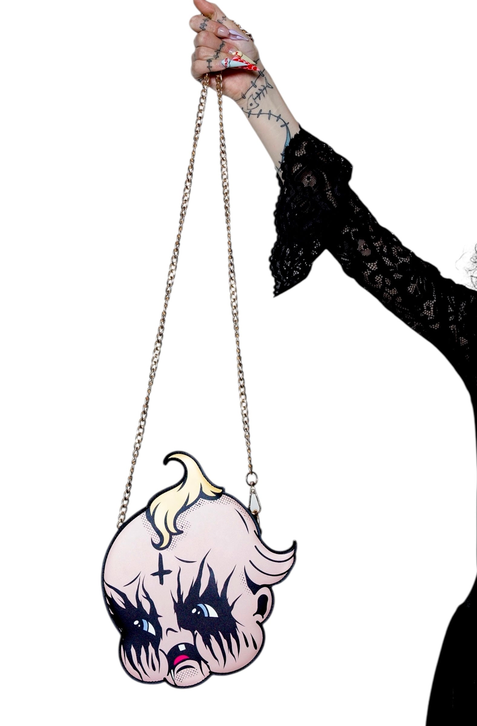 Hand holding a unique handbag with a stylized face design against a white background
