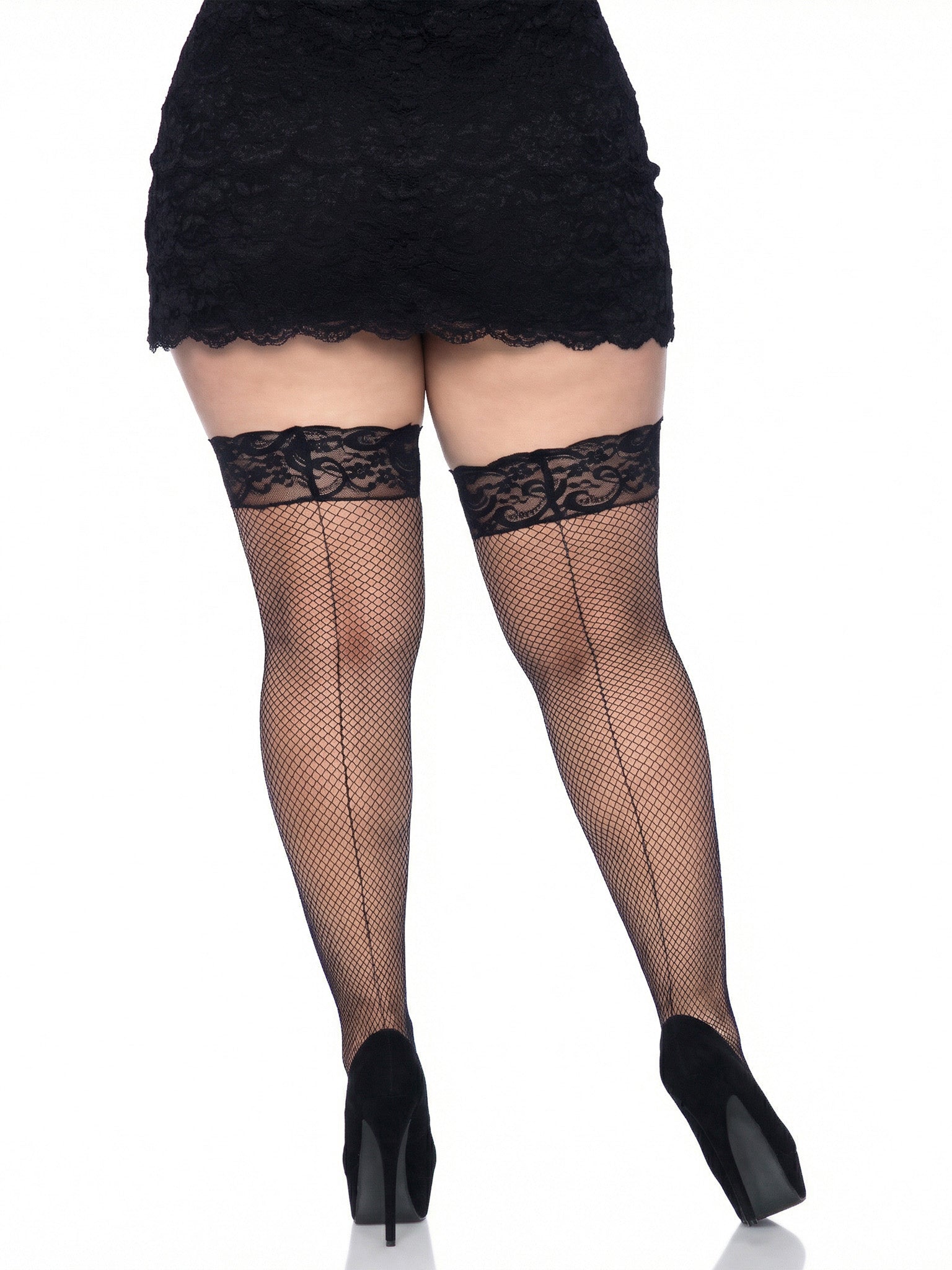 Person wearing black lace fishnet stockings with a plain background