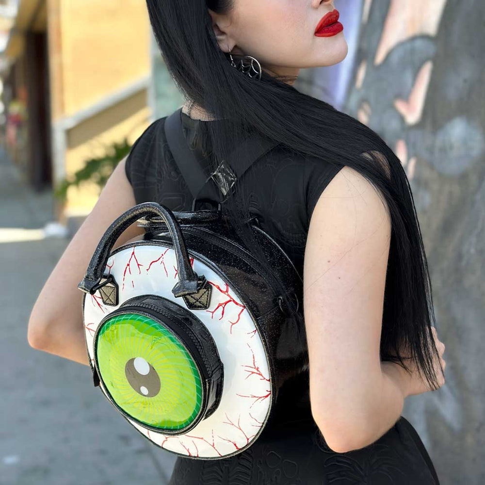 Person wearing a unique backpack with a large eye design.