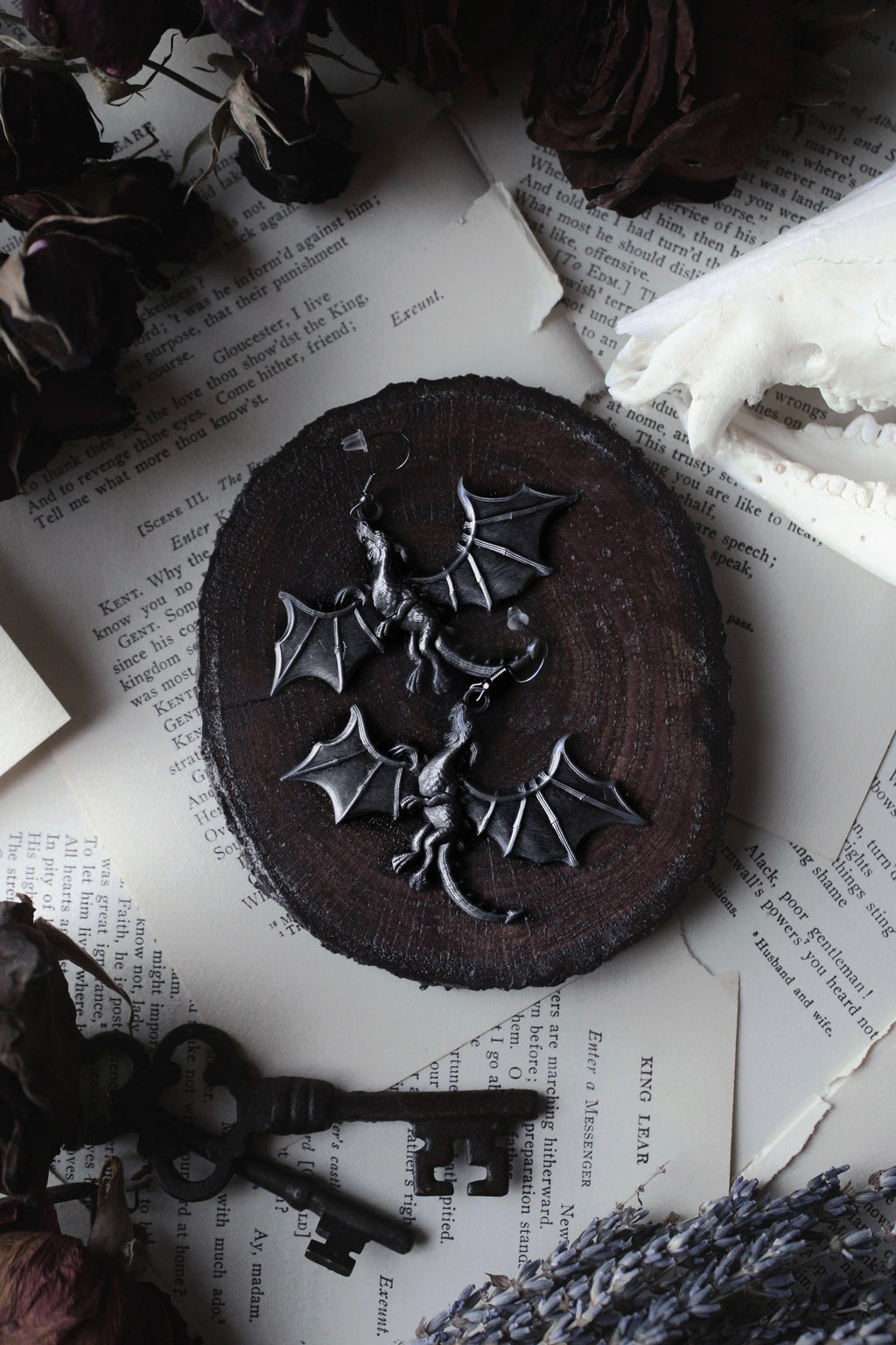 Dark chocolate cookie with a dragon decoration on a textured surface with keys and dried flowers.