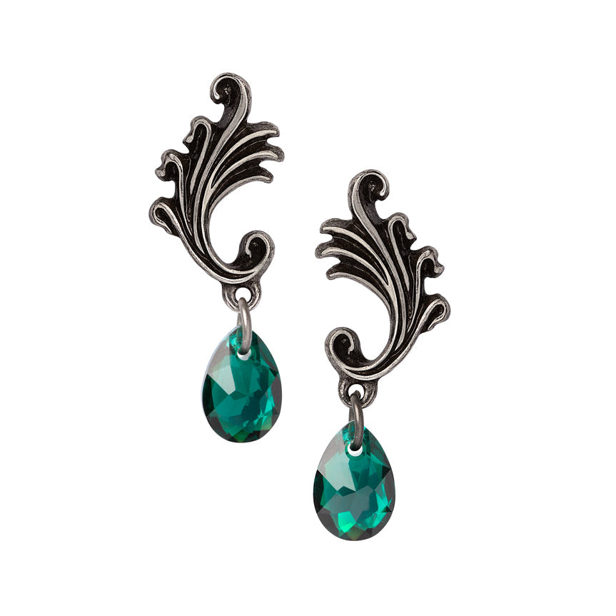 Pair of earrings with decorative metalwork and green gemstones on a white background
