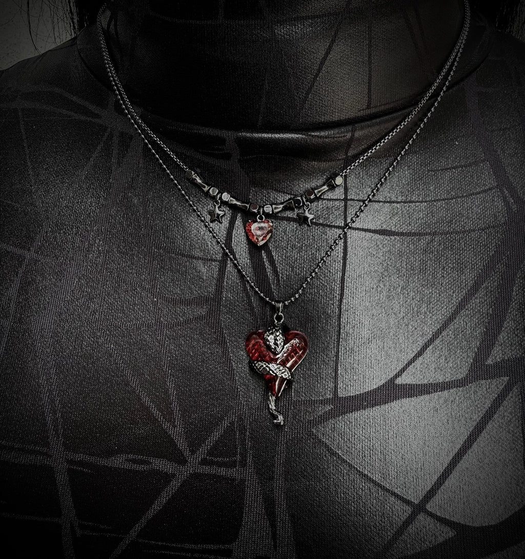 Necklace with a heart-shaped pendant worn by a person against a dark background