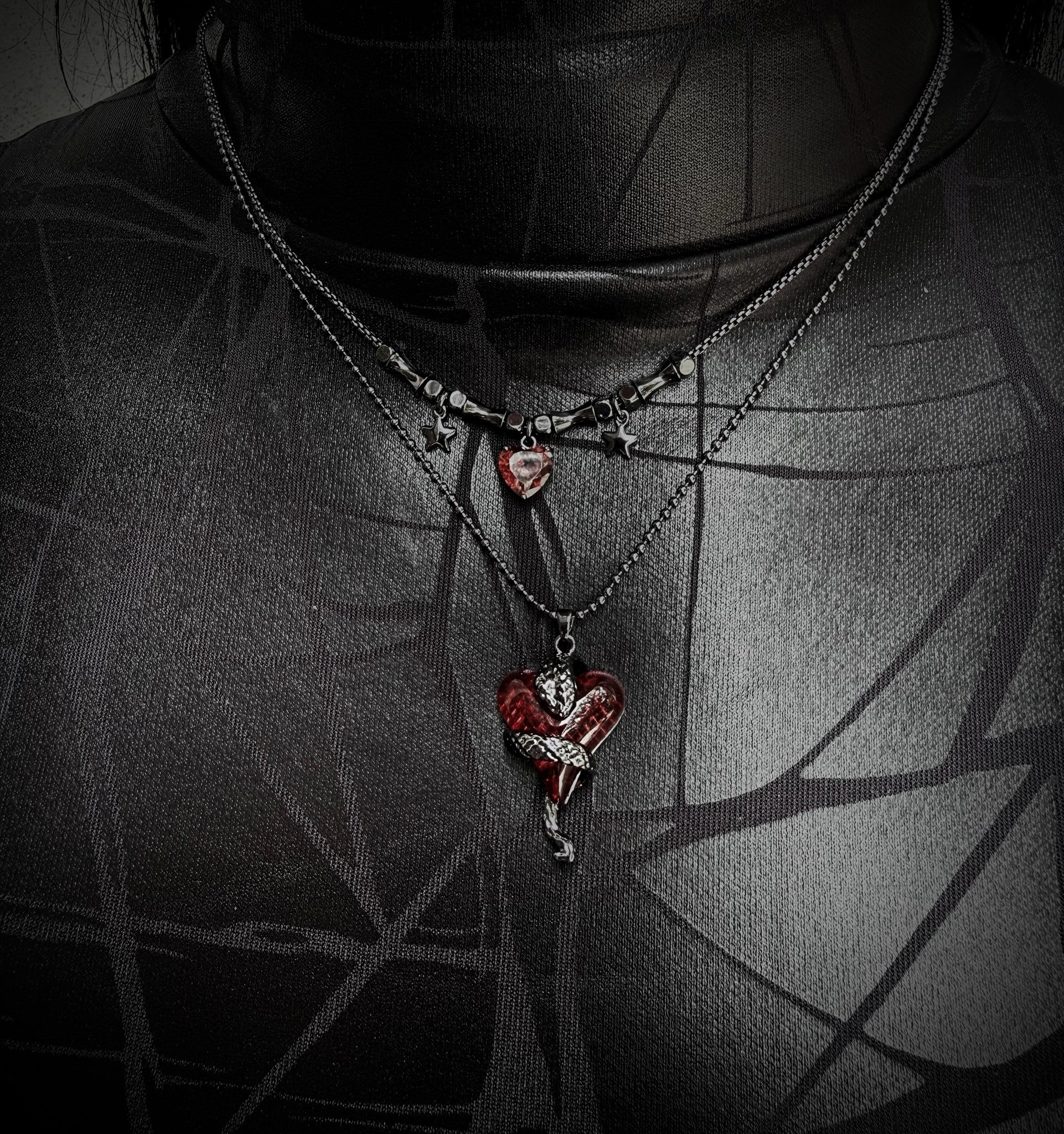 Necklace with a heart-shaped pendant worn by a person against a dark background