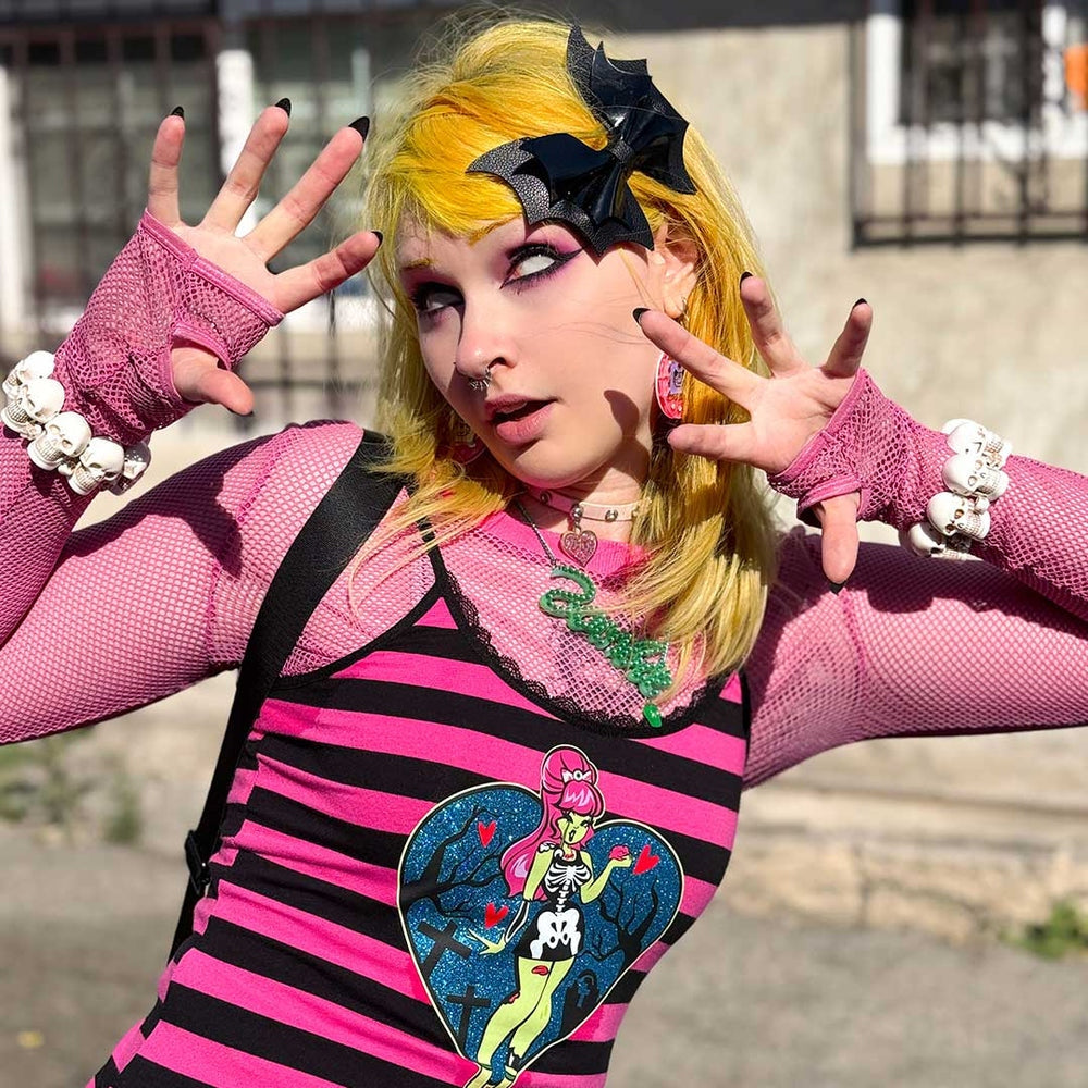 Person in a colorful costume with pink gloves and a striped shirt featuring a graphic design.