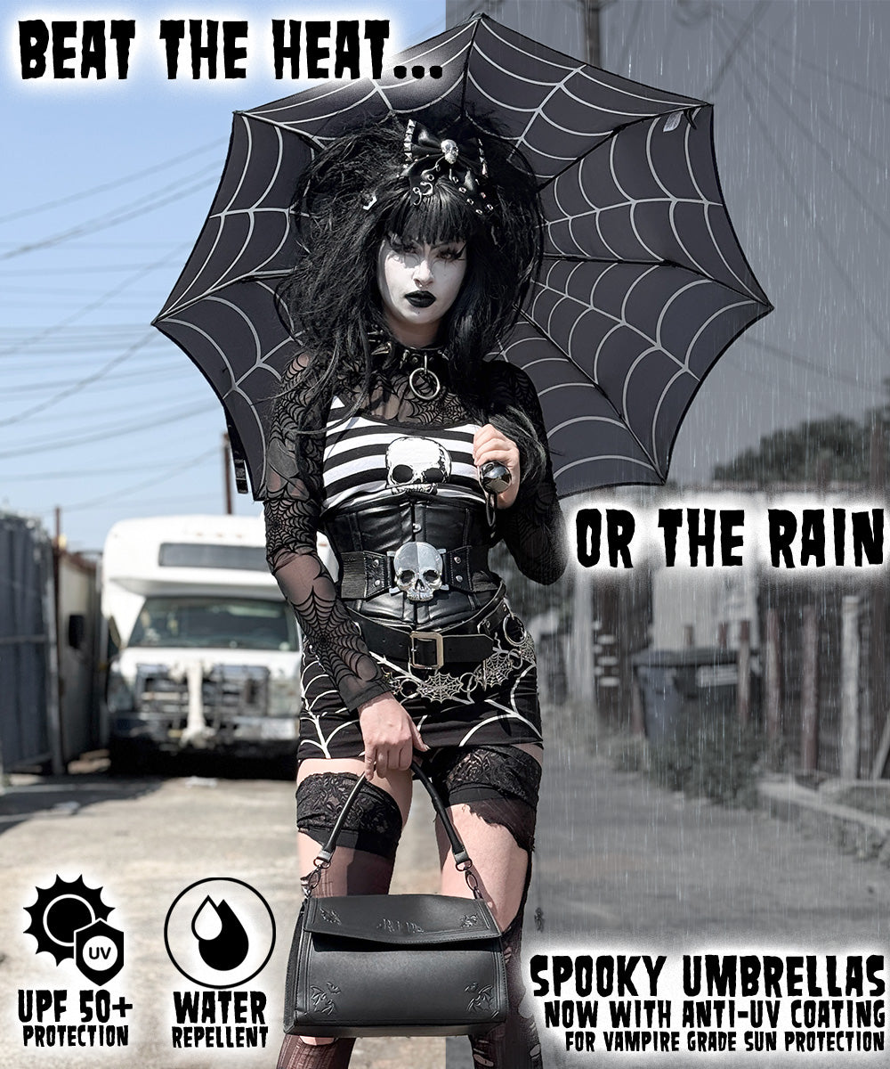 Person holding a black spider-web umbrella with promotional text and logos for a spooky umbrella.