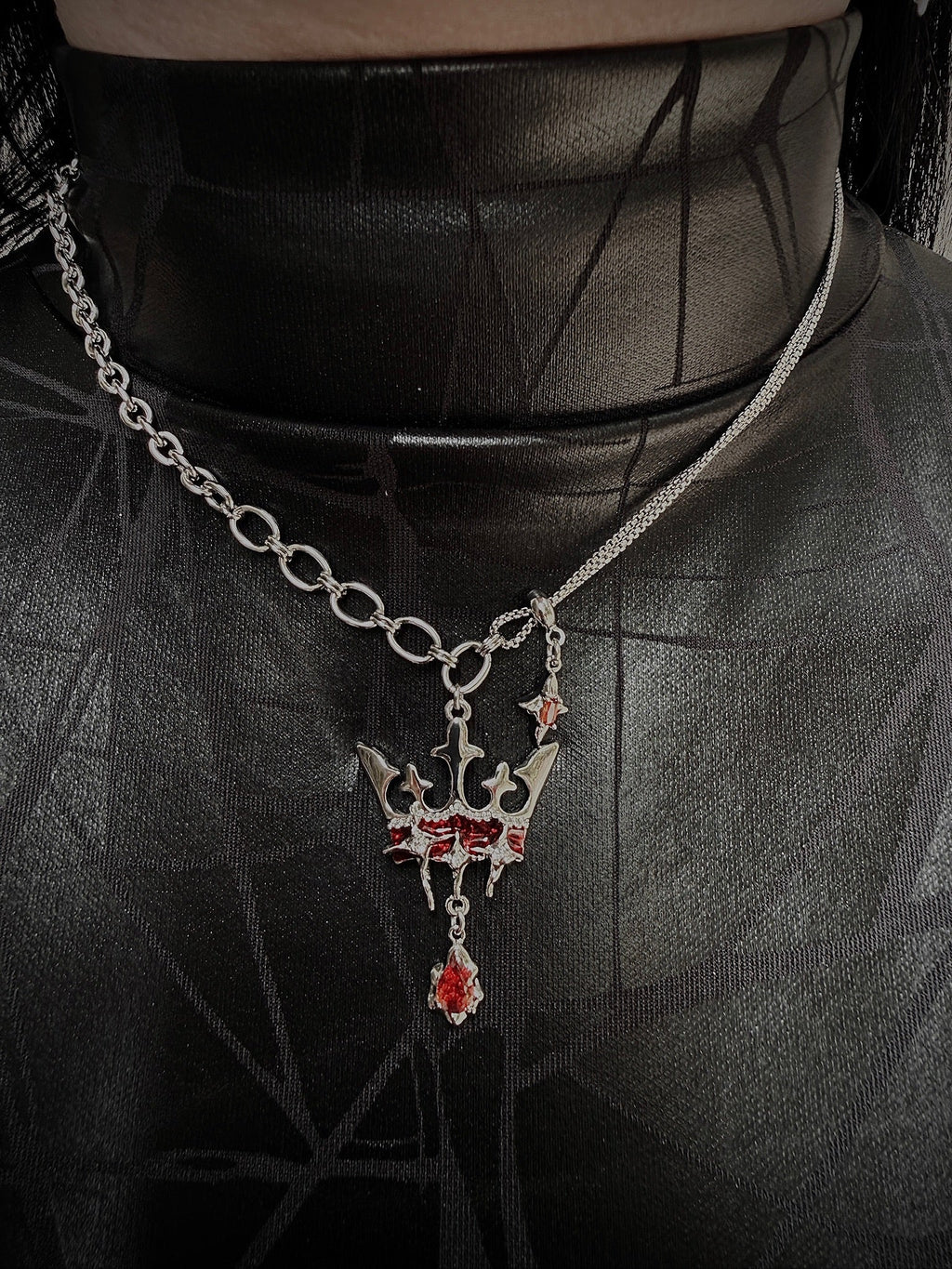 Necklace with a detailed pendant on a dark fabric background
