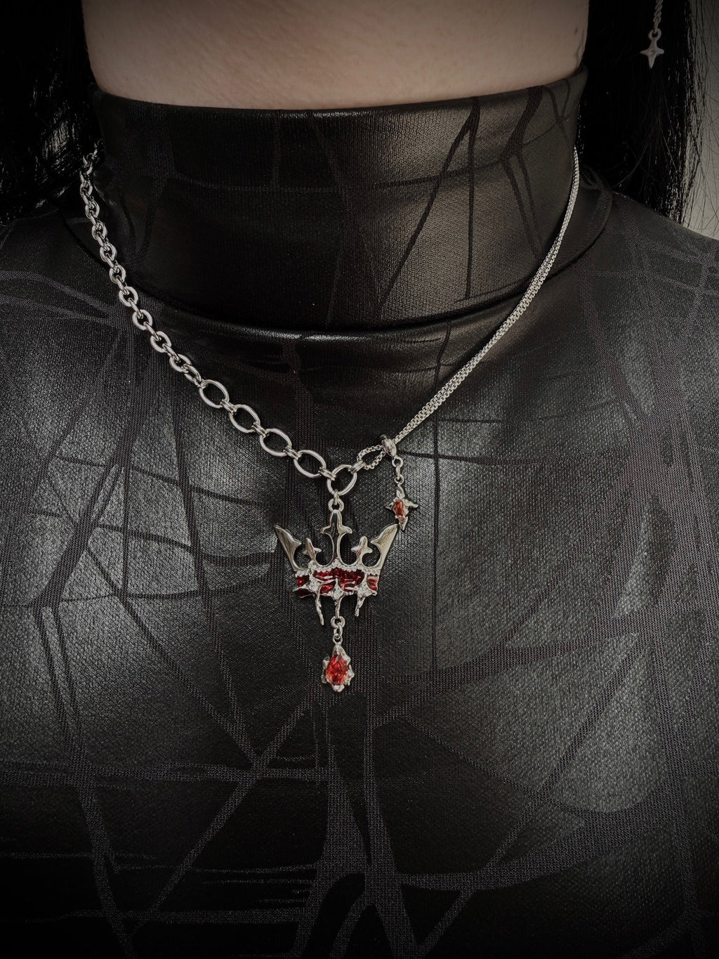 Necklace with a pendant worn by a person against a dark background