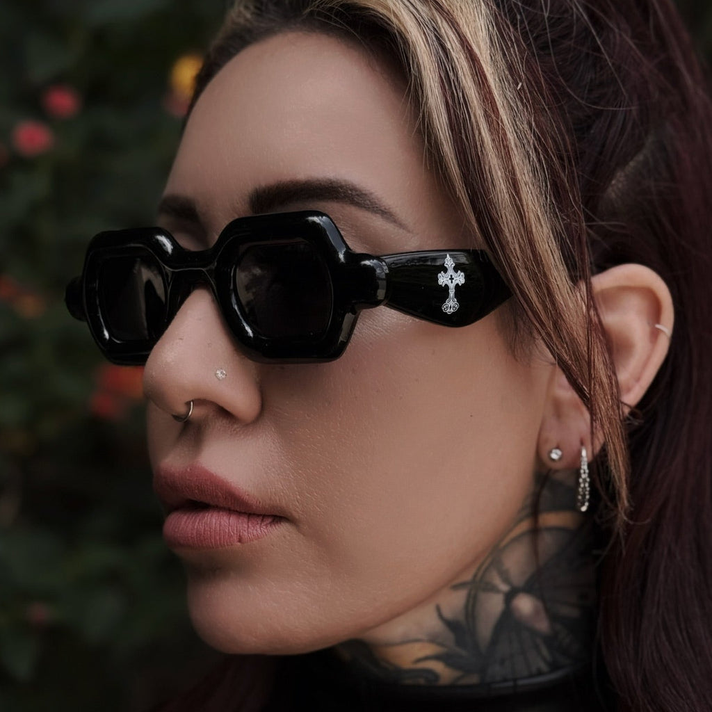 Person wearing black sunglasses with a blurred natural background