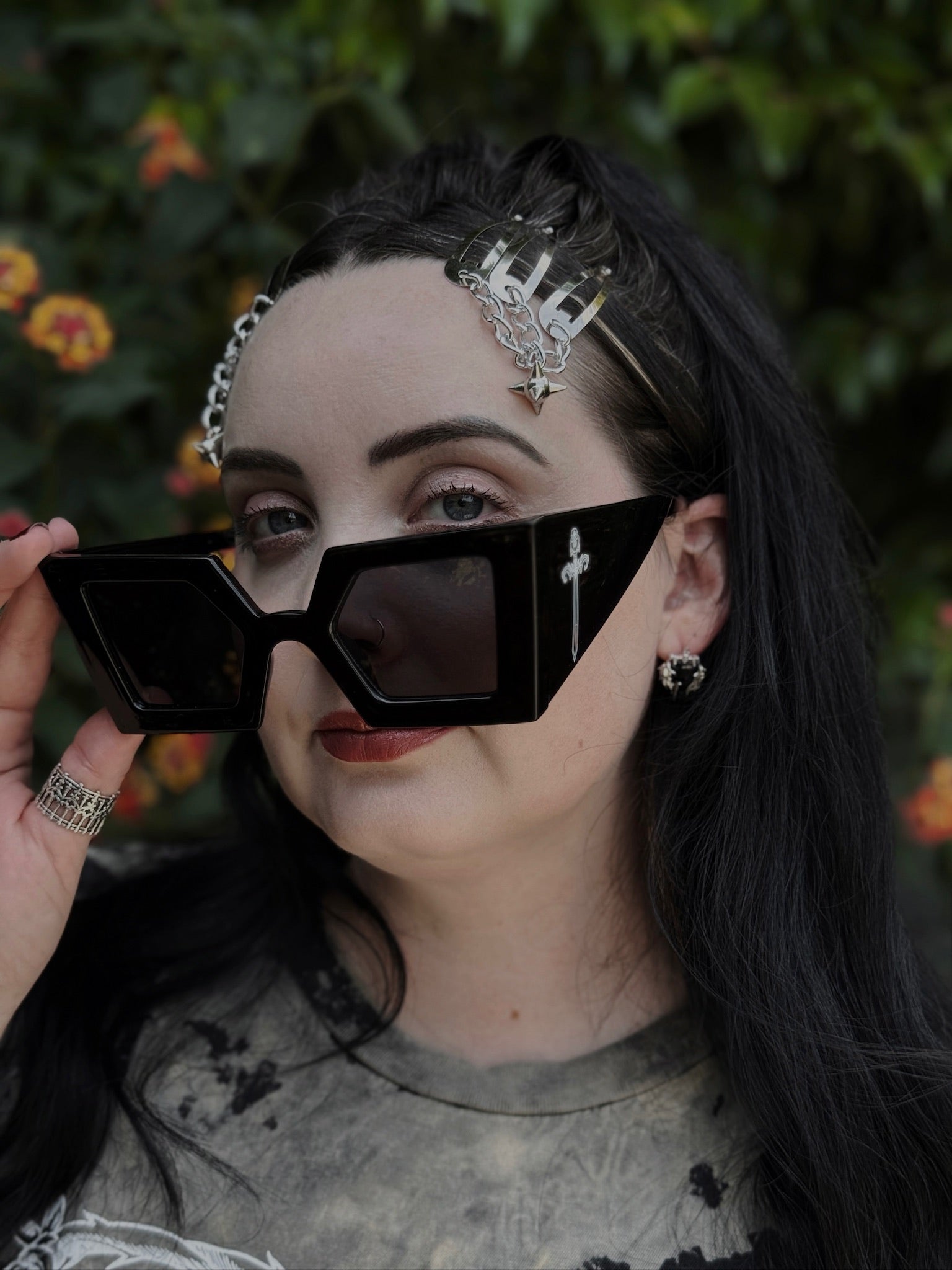 Person wearing black sunglasses with a blurred natural background