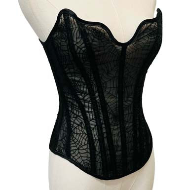 Black lace corset on a mannequin against a white background