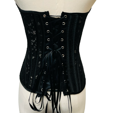 Black corset on a mannequin against a white background