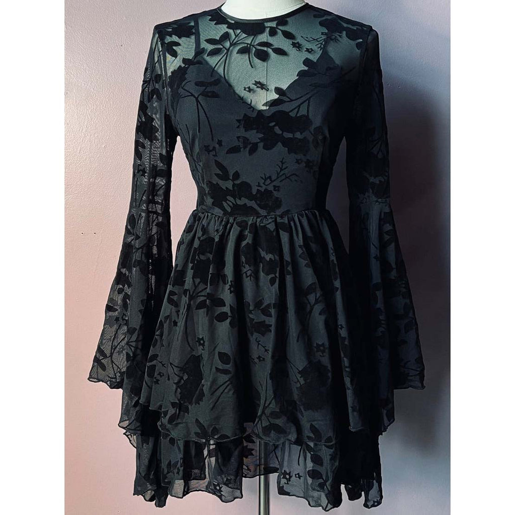 Black floral dress on a mannequin against a plain background