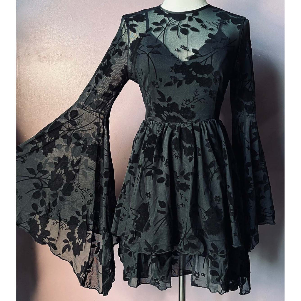 Black floral dress on a mannequin against a plain background