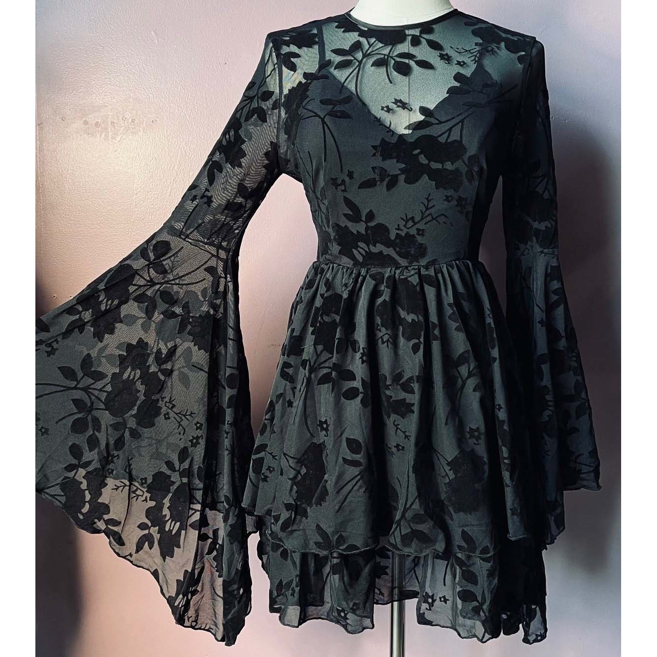 Black floral dress on a mannequin against a plain background