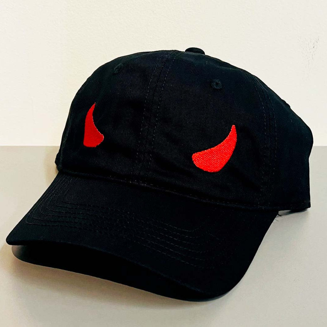 Black cap with red devil horns on a white background