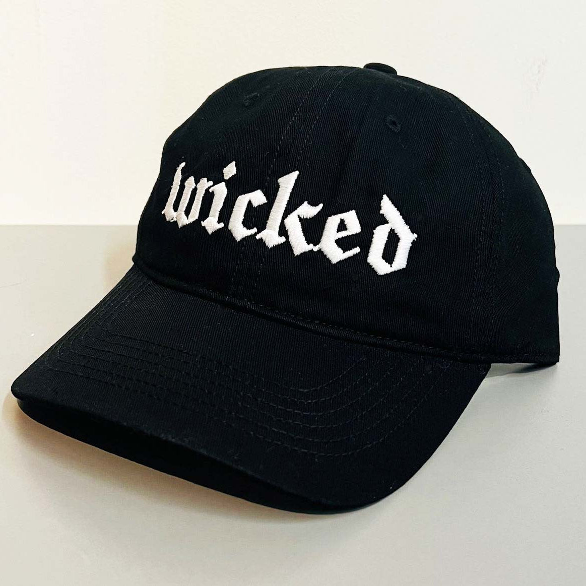 Black cap with 'wicked' text on a white background