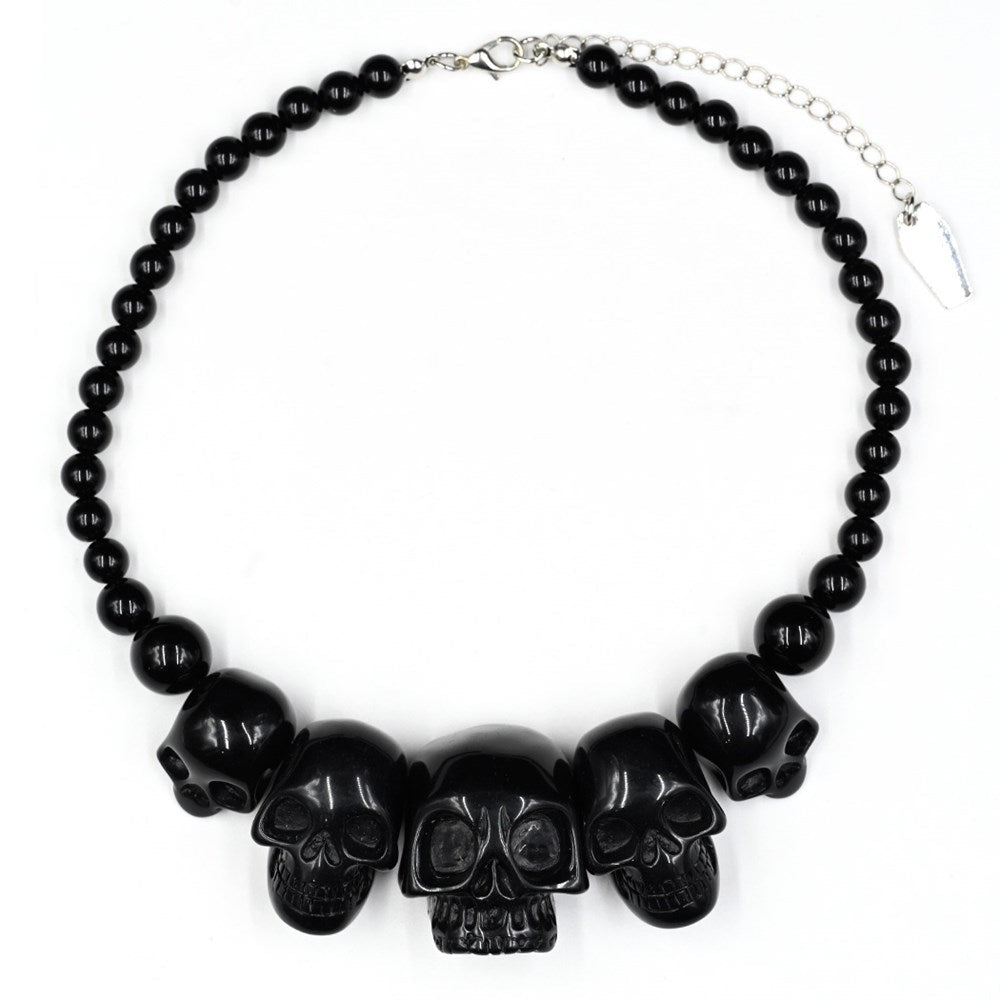 Black beaded necklace with skull designs on a white background