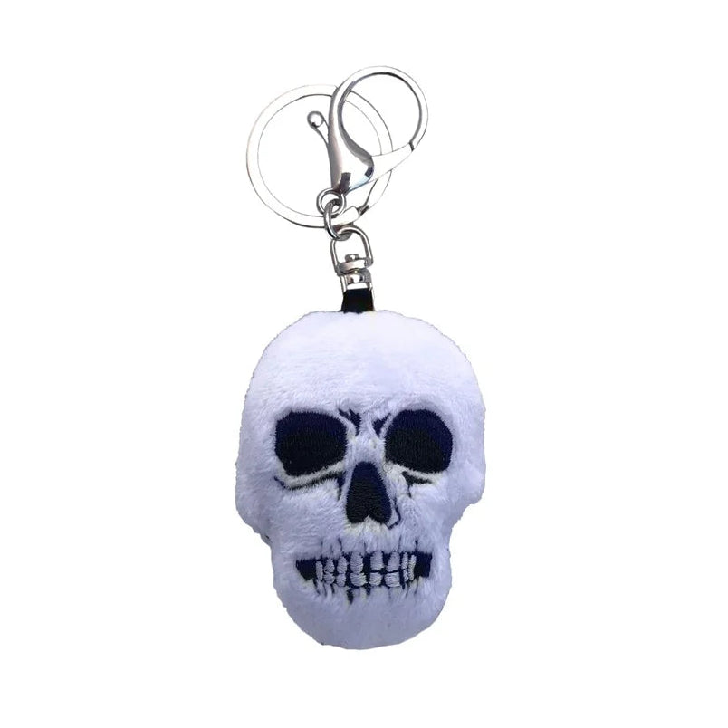 A plush skull keychain with black embroidered details and a silver metal clasp on a plain white background.