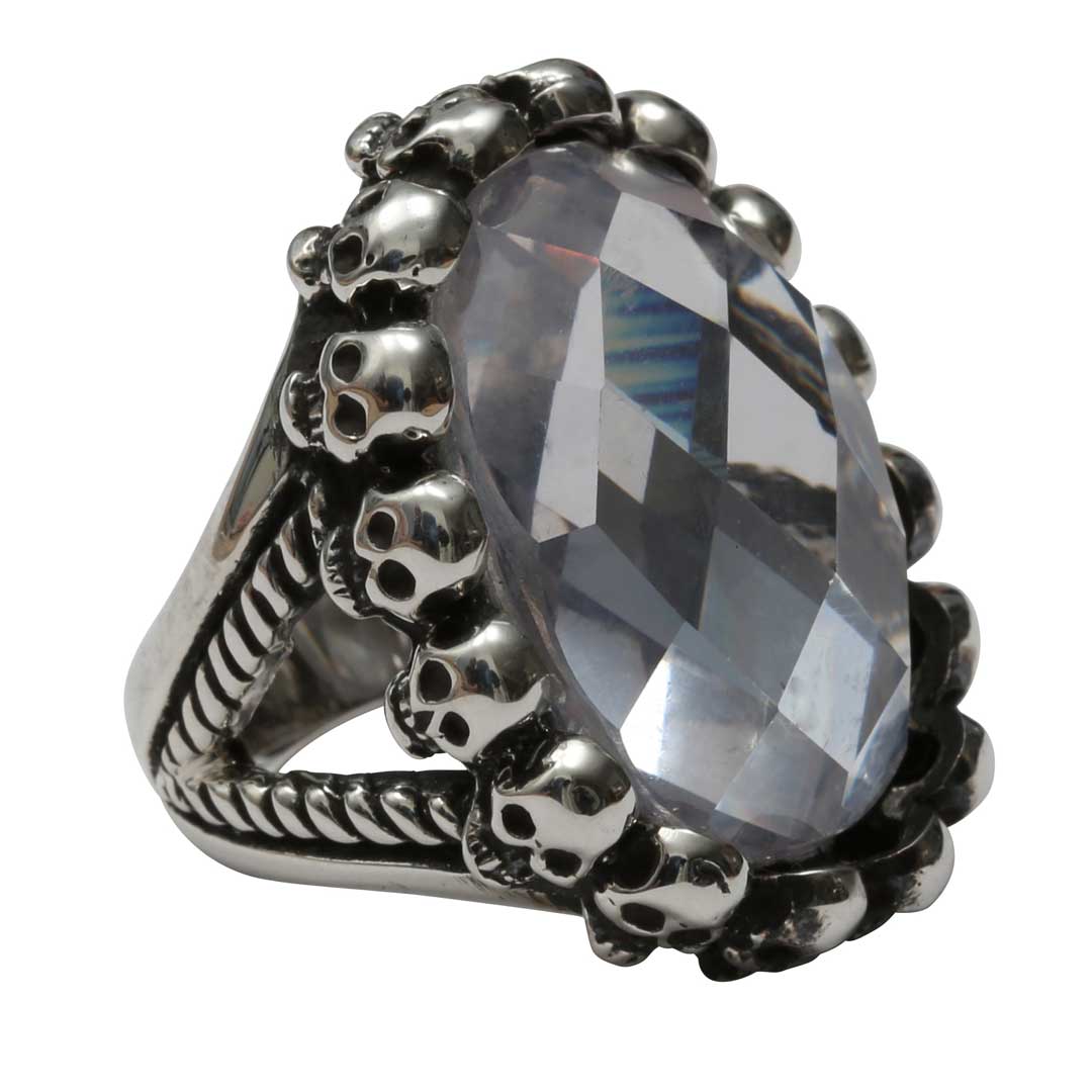 Silver ring with skull design and clear gemstone on a white background