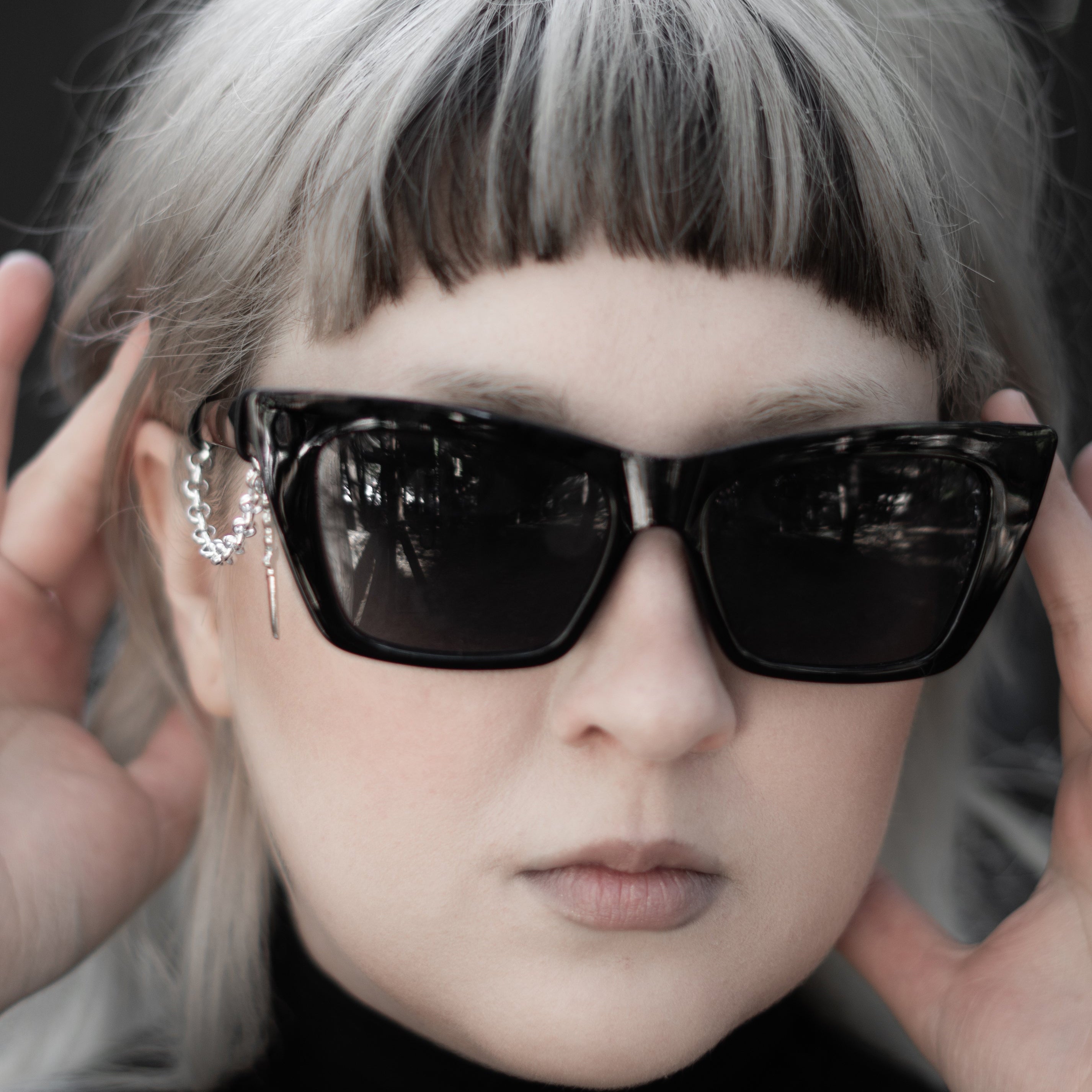 Person wearing black sunglasses with a blurred background