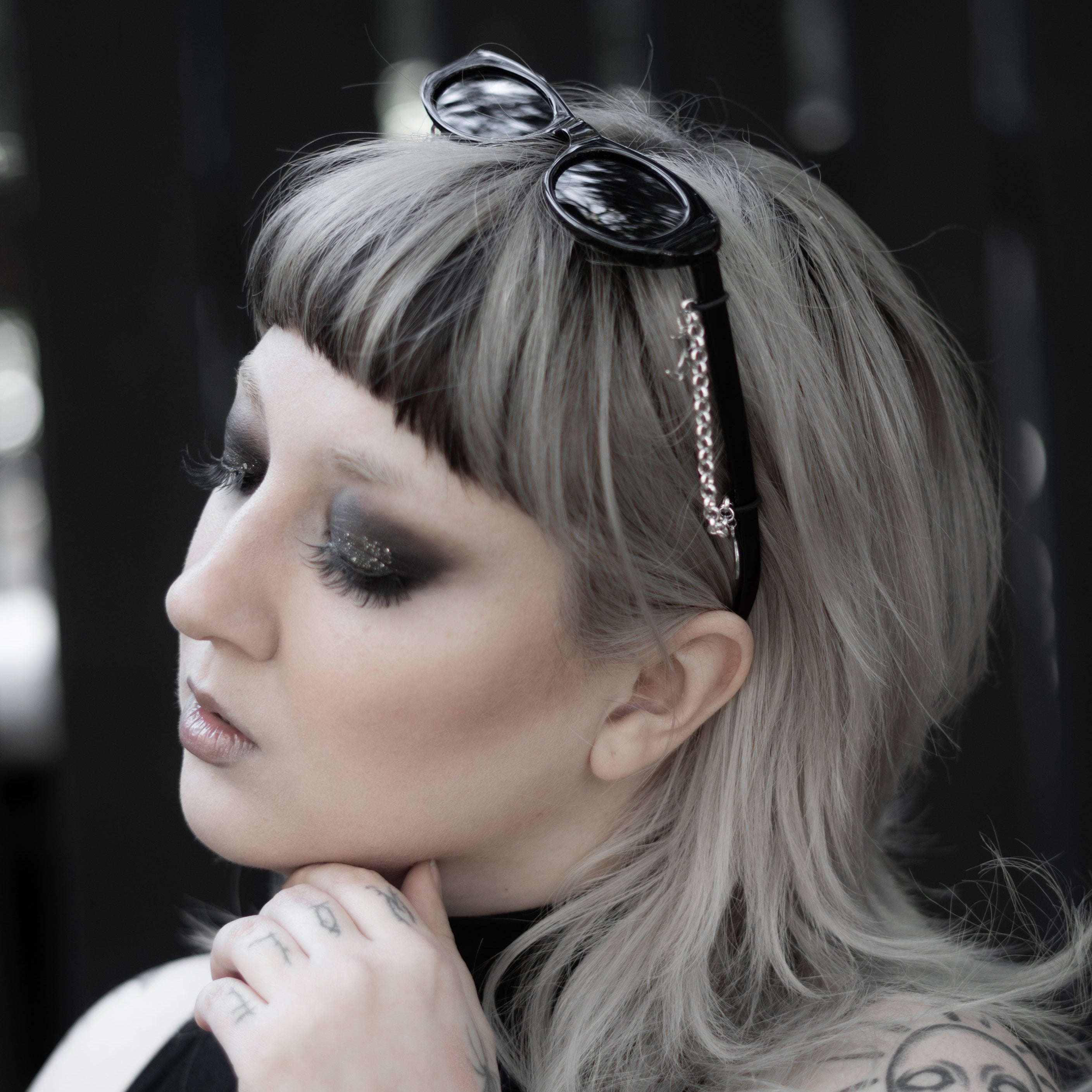 Woman with tattoos and sunglasses on her head against a blurred background