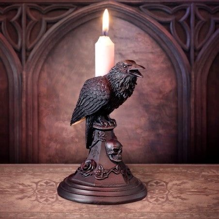 Candle holder with a crow design on a wooden surface with a decorative background