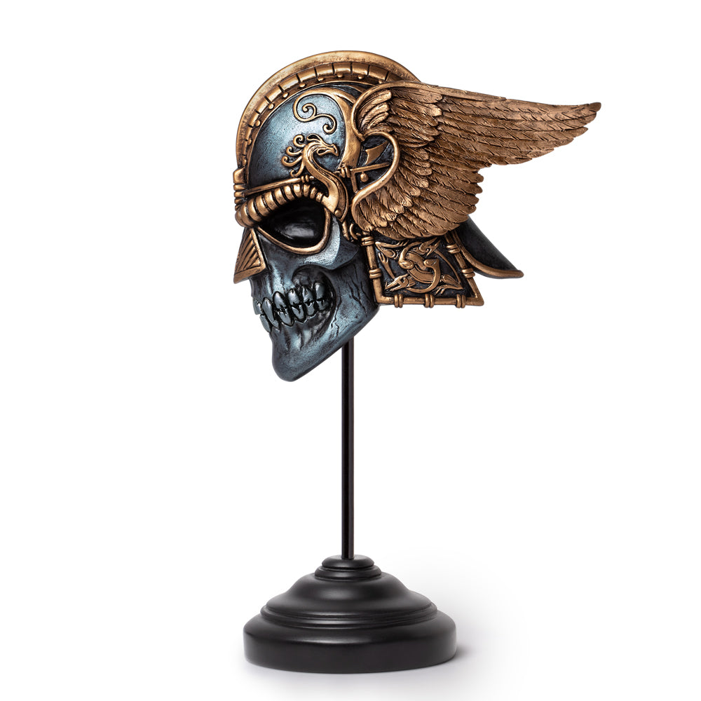 Decorative skull mask with wings on a stand against a white background