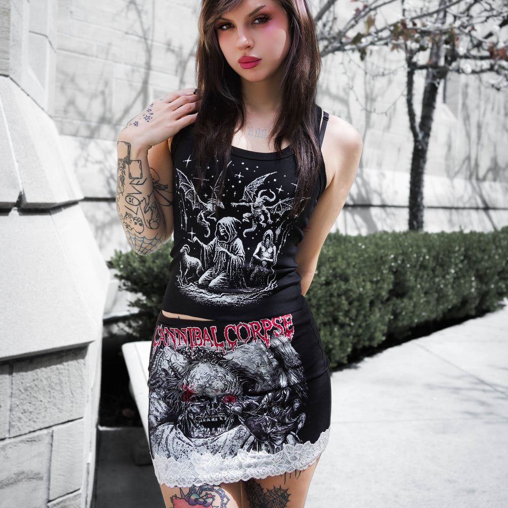 Woman wearing a black tank top with graphic designs outdoors.