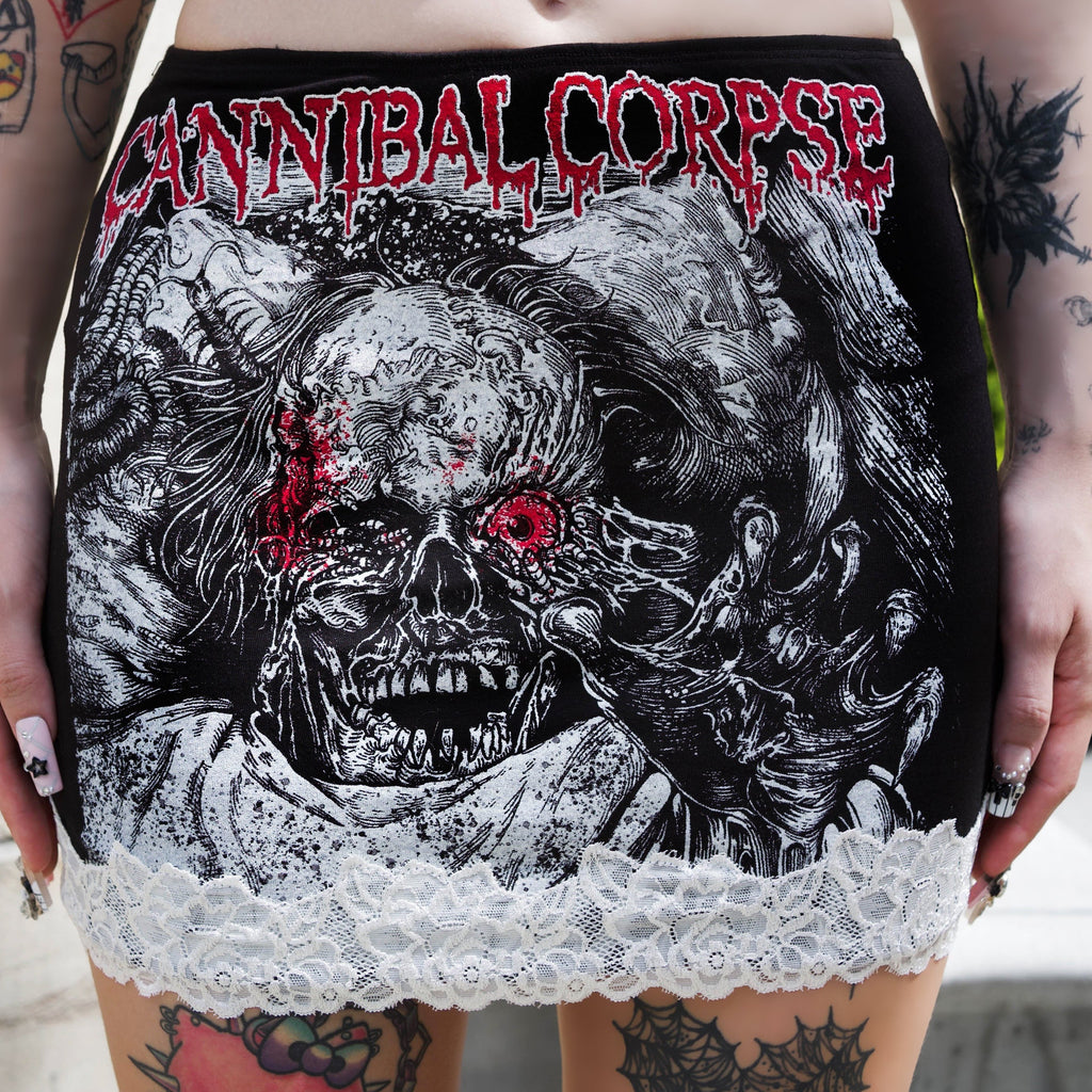 Person wearing a black and red 'Cannibal Corpse' skirt with a skull design.
