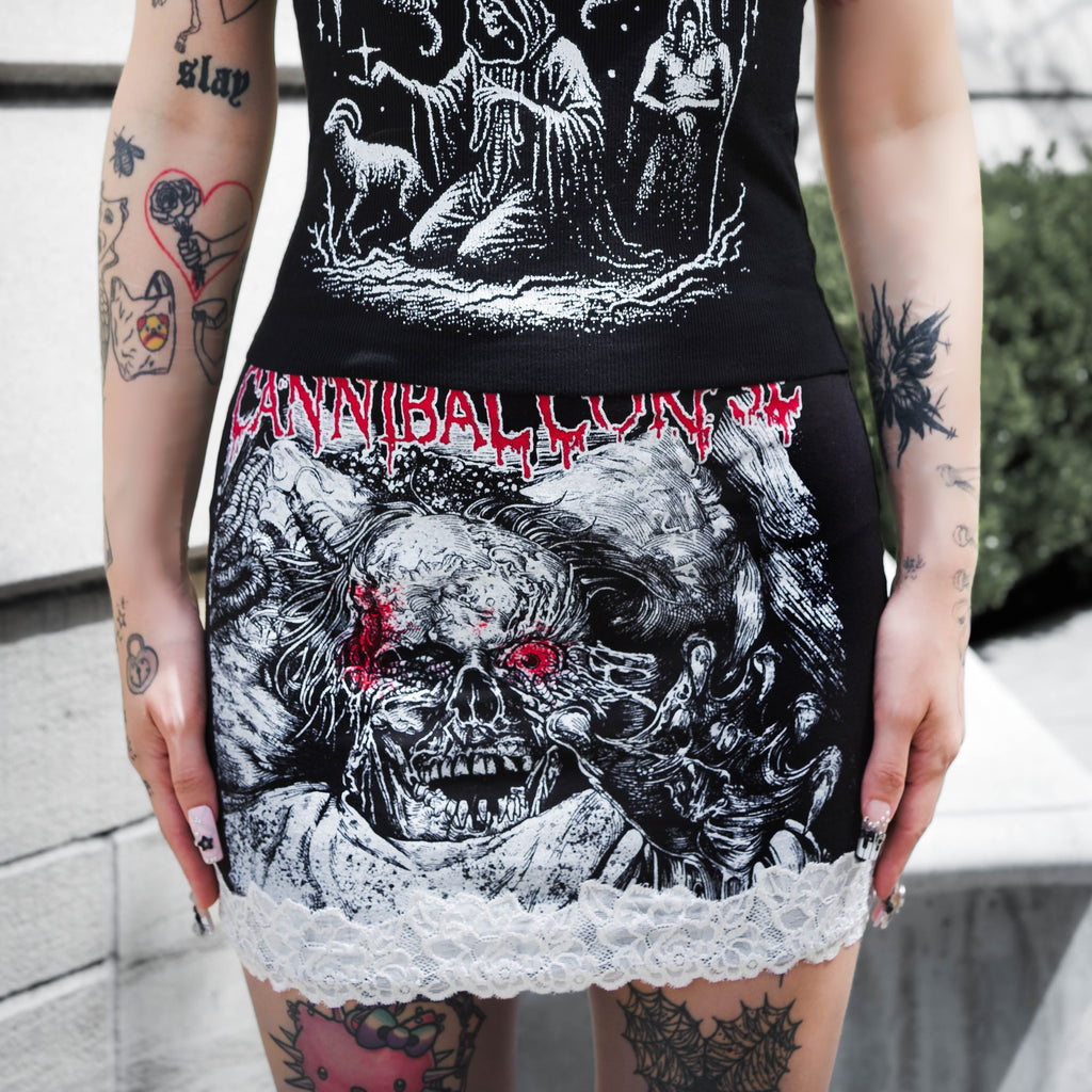 Black tank top with graphic designs and text worn by a person outdoors.